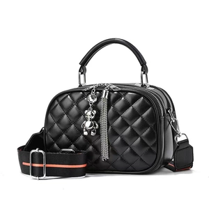 Chic black quilted handbag with silver bear charm and wide striped shoulder strap