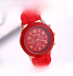 Detail of red silicone strap and rose gold watch case with decorative sub-dials