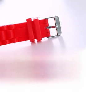 Detail of red silicone watch strap with adjustable stainless steel buckle closure