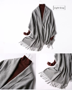 Detail view of light grey wool shawl with fine fringe edges and knit texture