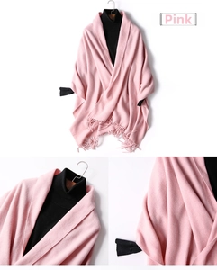 Close-up of pink wool shawl texture with handmade fringe details and soft knitted fabric