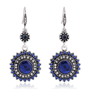 Detail of vintage silver stud earrings featuring blue crystal sunflower design and gems