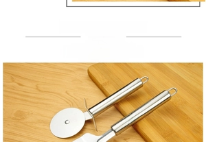 Macro view of stainless steel pizza cutter and cake shovel on a wooden cutting board