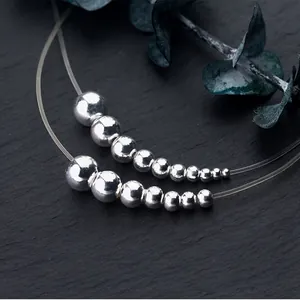 Polished S925 sterling silver round beads in gradient sizes on high-end stone surface