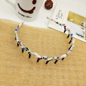 Floral fabric wrapped headband with teeth on a rustic woven mat for hair styling