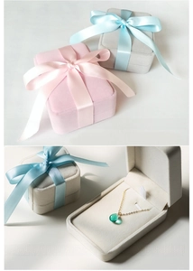 Detail of square velvet jewelry boxes with elegant ribbon bows for necklace packaging