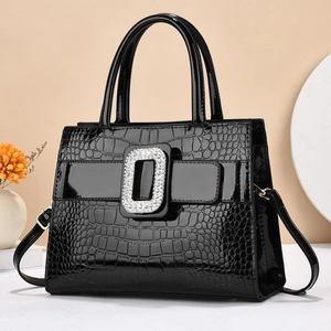 Detalle de bolso negro brillante de imitación cocodrilo con hebilla de diamante brillante