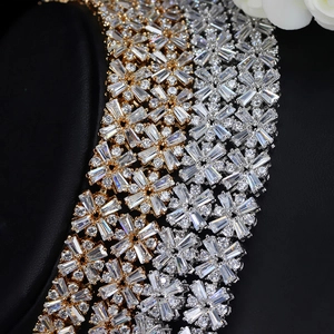 Macro shot of gold and silver snowflake necklaces with zircon inlay on black leather