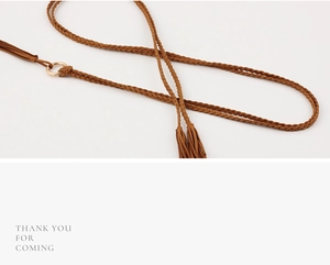 Detail of brown braided waist belt showing intricate woven texture and fringe tassels