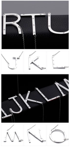 Macro detail of silver stainless steel letter pendants with sparkling rhinestones set