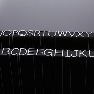 Polished silver stainless steel necklace with sparkling initial letter charms on black leather