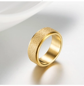 Close-up of wide gold stainless steel spinner ring with frosted sandblasted finish