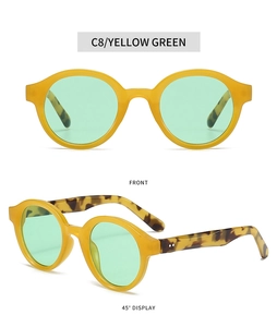 Detail view of oval retro sunglasses with yellow frames and tortoise temples