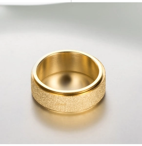 Detailed view of wide gold rotatable ring with frosted finish and polished inner surface