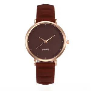 Macro view of dark brown quartz watch face and rose gold casing with wavy silicone strap