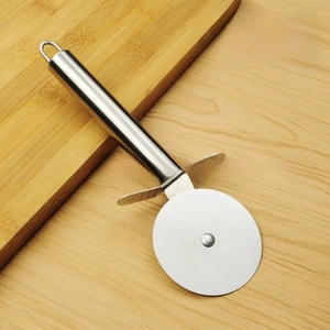 Detail of stainless steel pizza cutter wheel with guard on rustic wooden board