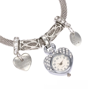 Macro detail of silver heart quartz watch with rhinestones and engraved metal pendants