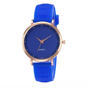 Close-up of bright blue silicone strap and rose gold quartz watch on white background