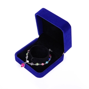 Close-up of a multi-color gemstone bracelet with heart pendant in a blue velvet jewelry box