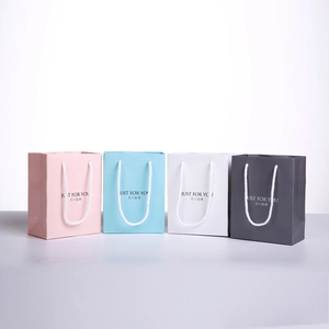 White, pink, blue and grey small jewelry gift bags with white handles and printed text