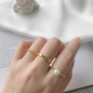 Detail view of gold S925 silver ring featuring chevron pattern and pearl on hand