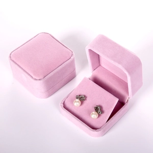 Macro view of octagonal pink velvet jewelry box with pearl butterfly earrings
