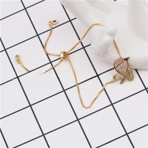 Detail of adjustable gold-plated box chain bracelet featuring a micro-paved boy charm