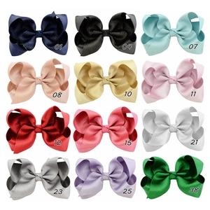 Detailed grid view of twelve glittery polyester bow hair clips in assorted vibrant colors