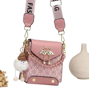 Macro detail of pink crossbody bag featuring swan pearl clasp and luxury monogram texture