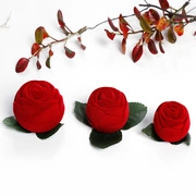 Detail of red rose ring box with flocked velvet texture and green leaf base finish
