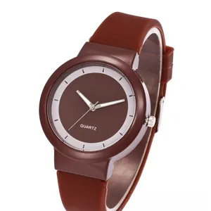 Detail view of brown minimalist quartz watch featuring a smooth silicone strap and clean dial