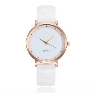 Macro shot of rose gold quartz watch with a minimalist white dial and silicone strap