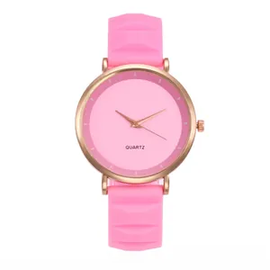 Detailed close-up of pink silicone watch strap with geometric texture and rose gold case