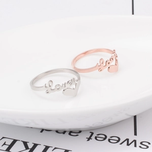 Détail des bagues cœur Love en or rose 18 carats et argent dans un plat en céramique