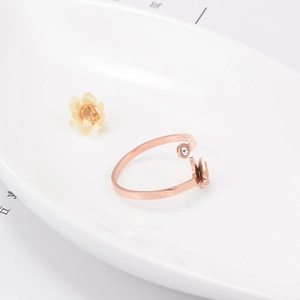 Gros plan d'une bague papillon en or rose 14k avec zircon sur plateau en céramique