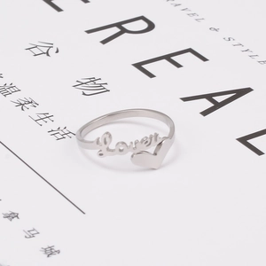 Vue rapprochée d'une bague argentée avec mot Lover et cœur sur un magazine