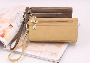 Detail of vintage long wallets in dark brown and tan with dual zippers and wrist straps