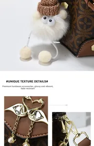 Macro shot of gold swan clasp and monogram texture on a brown crossbody bag