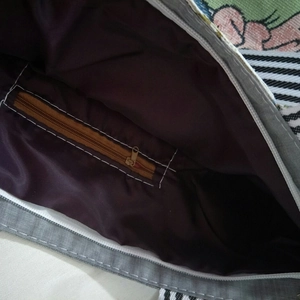 Detail view of jacquard canvas bag interior with satin lining and zip pocket