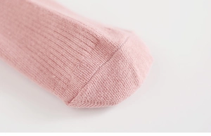 Close-up of pink cotton blend knit socks showing the soft ribbed texture and toe detail
