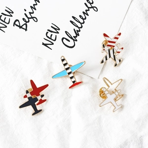 Lot de quatre broches d'avion en émail à rayures avec bordure dorée sur tissu