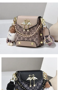 Detail of vintage pattern crossbody bag with swan buckle and pearl diamond accents