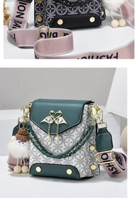 Detail of green leather flap cross-body bag with golden swan clasp and fashion strap