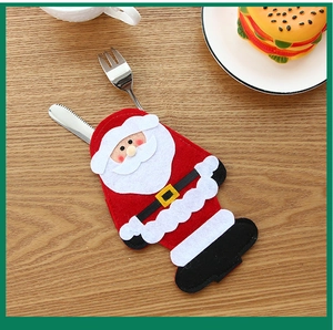 Detail view of Santa Claus cutlery holder on light wood background for Christmas table decor