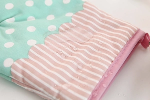 Detailed close-up showing waterproof water droplets on pastoral plaid oven mitt fabric