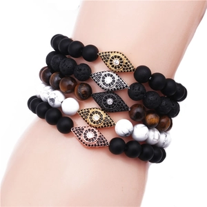 Detail of five beaded bracelets featuring lava stone, tiger eye and zircon evil eye charms