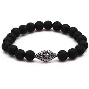 Macro shot of lava stone beads and a detailed evil eye charm with black white zircons