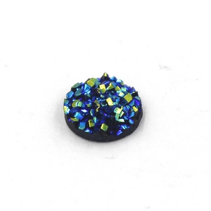 Macro detail of 8mm round blue and yellow resin druzy cabochon with glitter texture