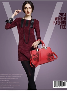 Detail of red PU leather tote bag with black ginkgo leaf patterns and petal metal buckle