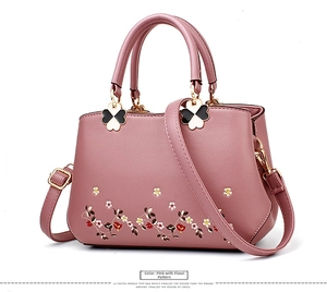 Detail of patterned rubber pink PU leather bag featuring exquisite floral embroidery work